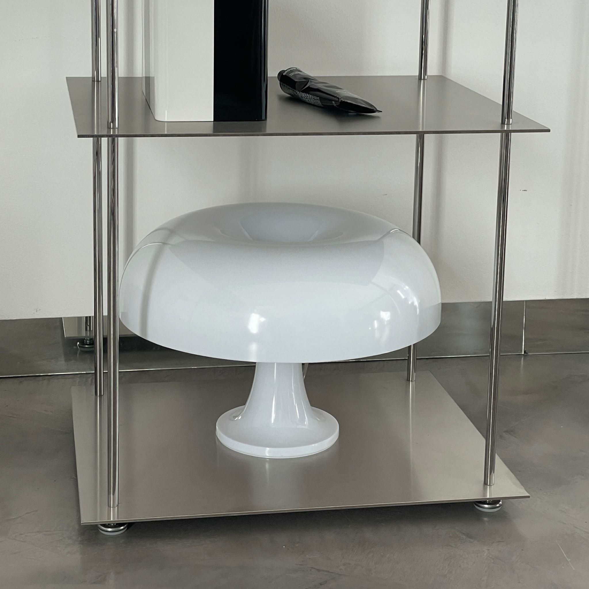 Detailansicht eines modularen Edelstahl-Regals mit Designerlampe und stilvollen Accessoires