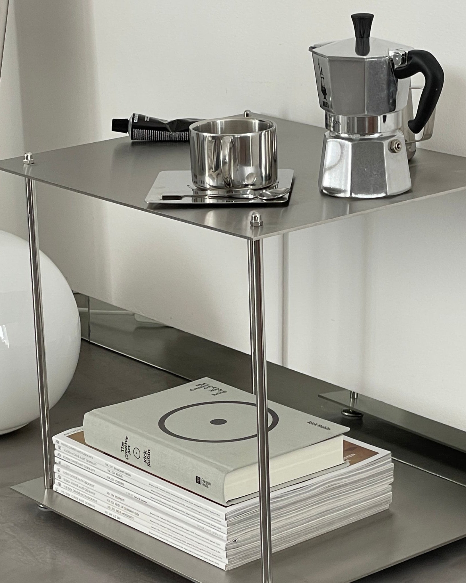 Modulares Regalsystem aus Edelstahl mit Kaffeemaschine, Tasse und Designmagazinen