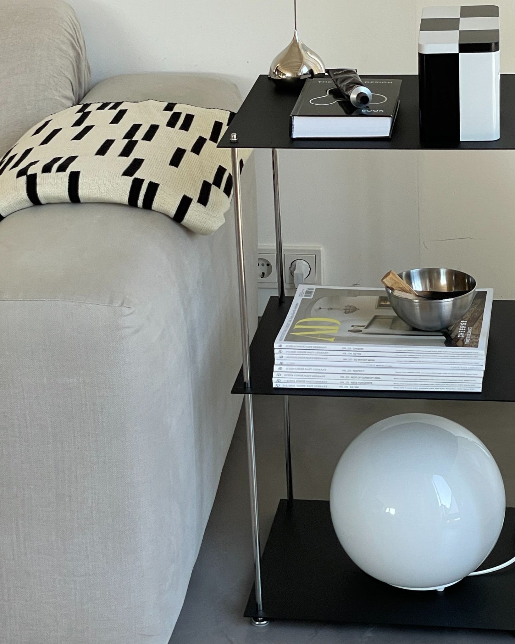 Schwarzes MODULUM Regal mit drei Ebenen, pulverbeschichtet und modern eingerichtet im Wohnzimmer