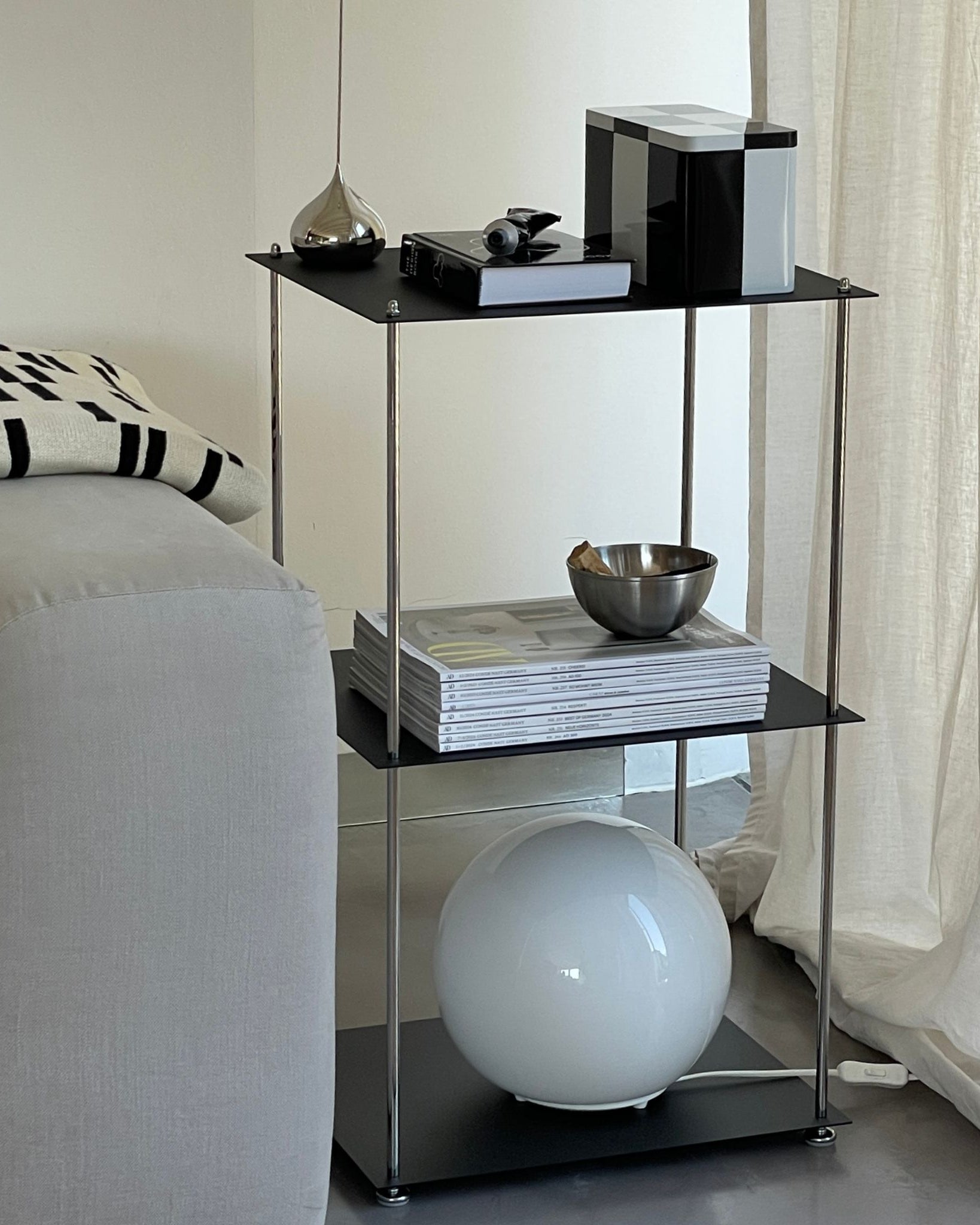 Modulares Regal in Schwarz mit pulverbeschichteten Böden und Edelstahlstreben im modernen Wohnzimmer