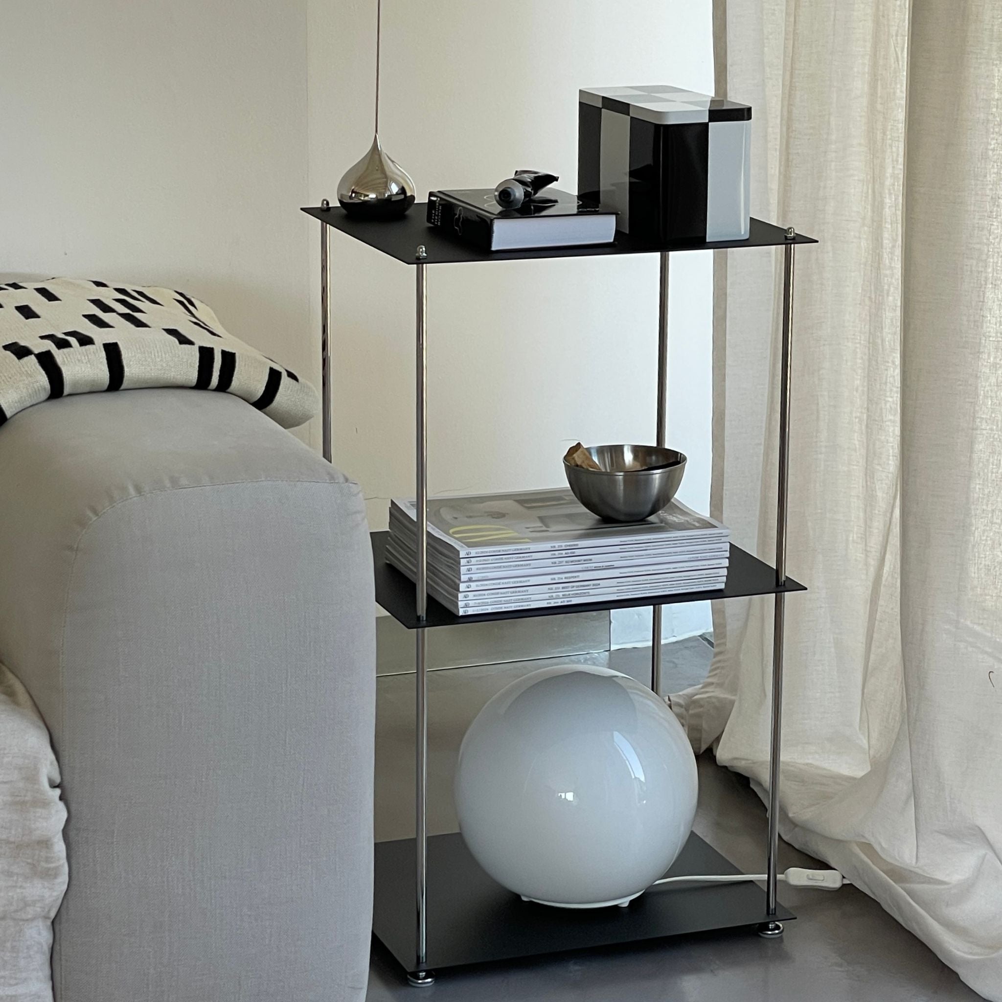 Modulares Regal in Schwarz mit pulverbeschichteten Böden und Edelstahlstreben im modernen Wohnzimmer