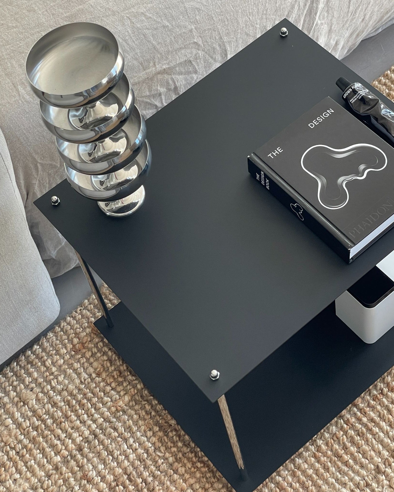 Detailansicht des MODULUM Beistelltischs in Schwarz mit Designobjekten – minimalistisches Möbelstück für stilvolle Räume