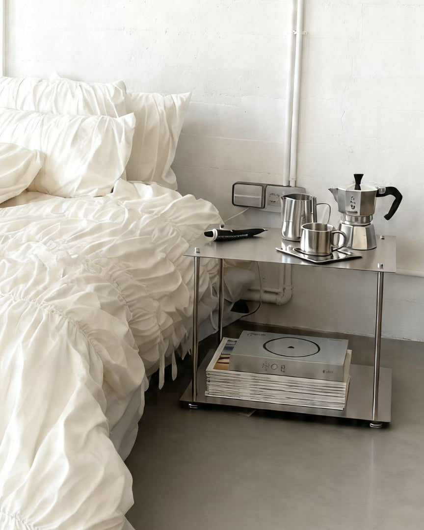 Modulares Regalsystem aus Edelstahl als Nachttisch im minimalistischen Schlafzimmer mit Kaffeeset und Stauraum