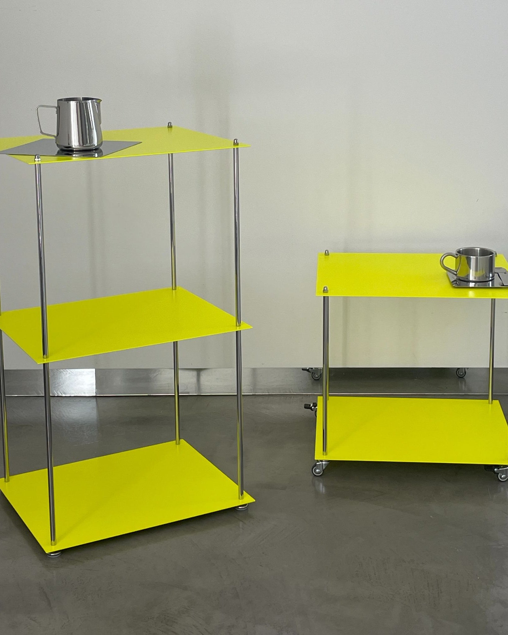 MODULUM Regal und Rollmodul in Leuchtgelb mit Edelstahlgestell auf grauem Boden vor weißer Wand