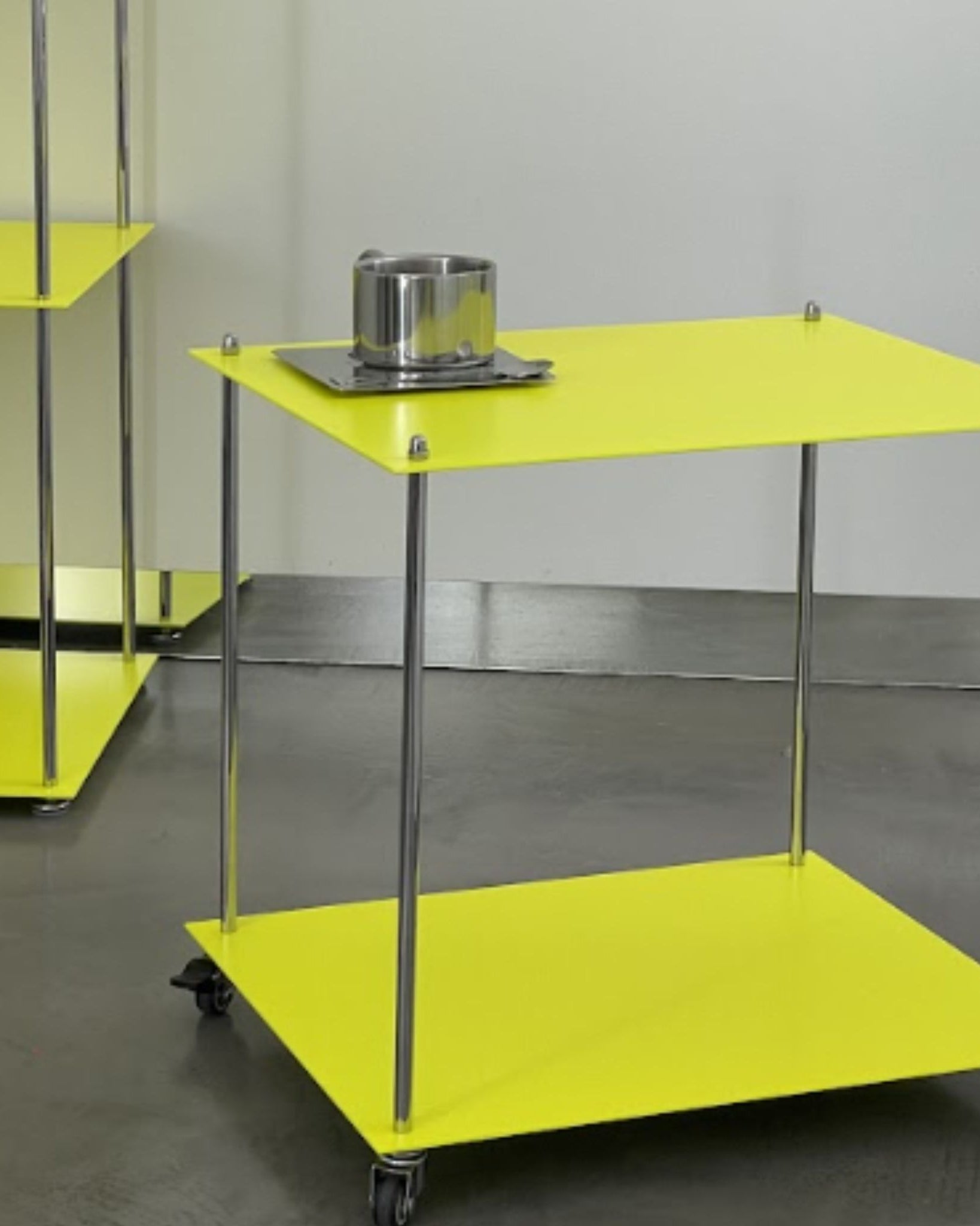 Designregal in Leuchtgelb mit Edelstahl-Tasse, rollbare Ausführung