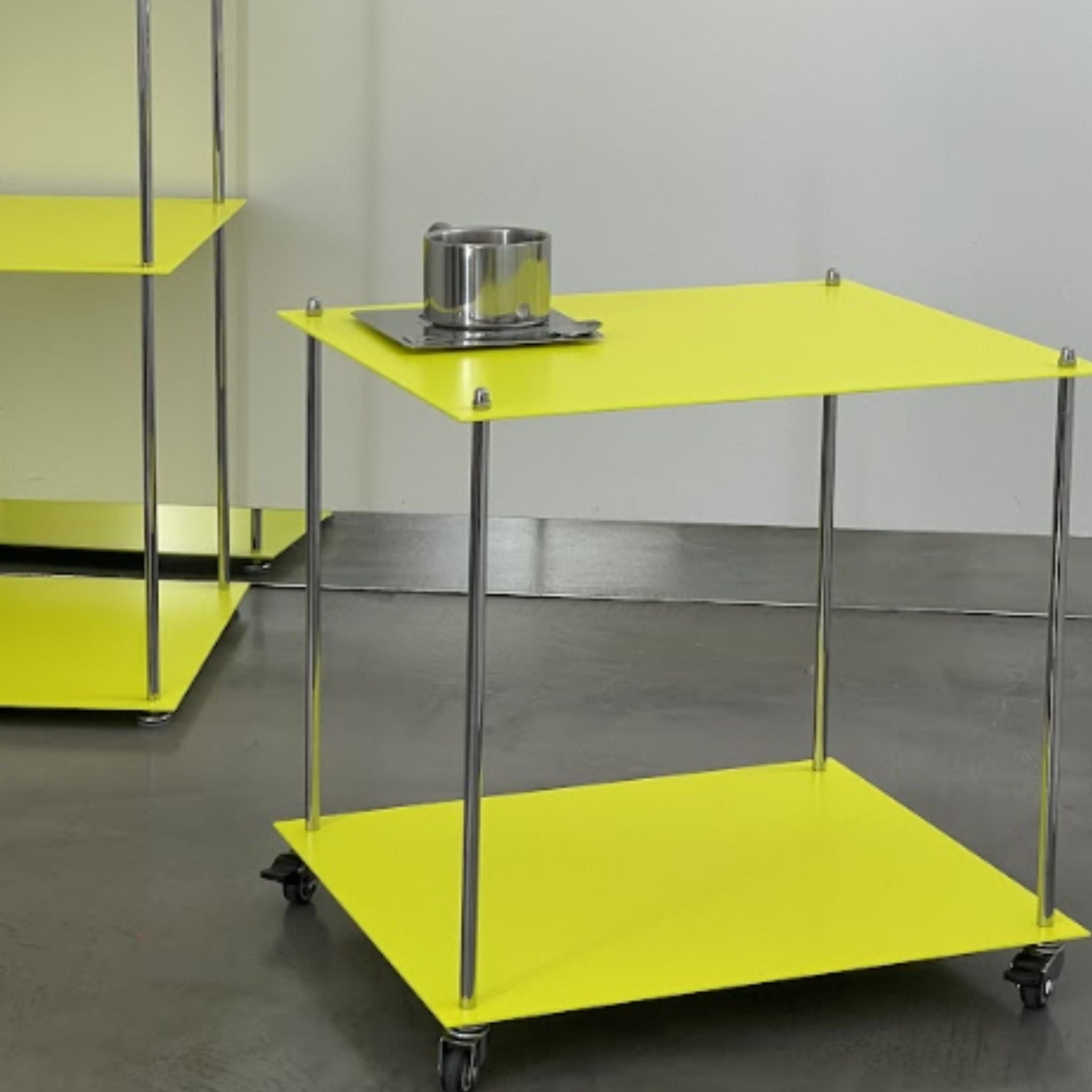 Designregal in Leuchtgelb mit Edelstahl-Tasse, rollbare Ausführung