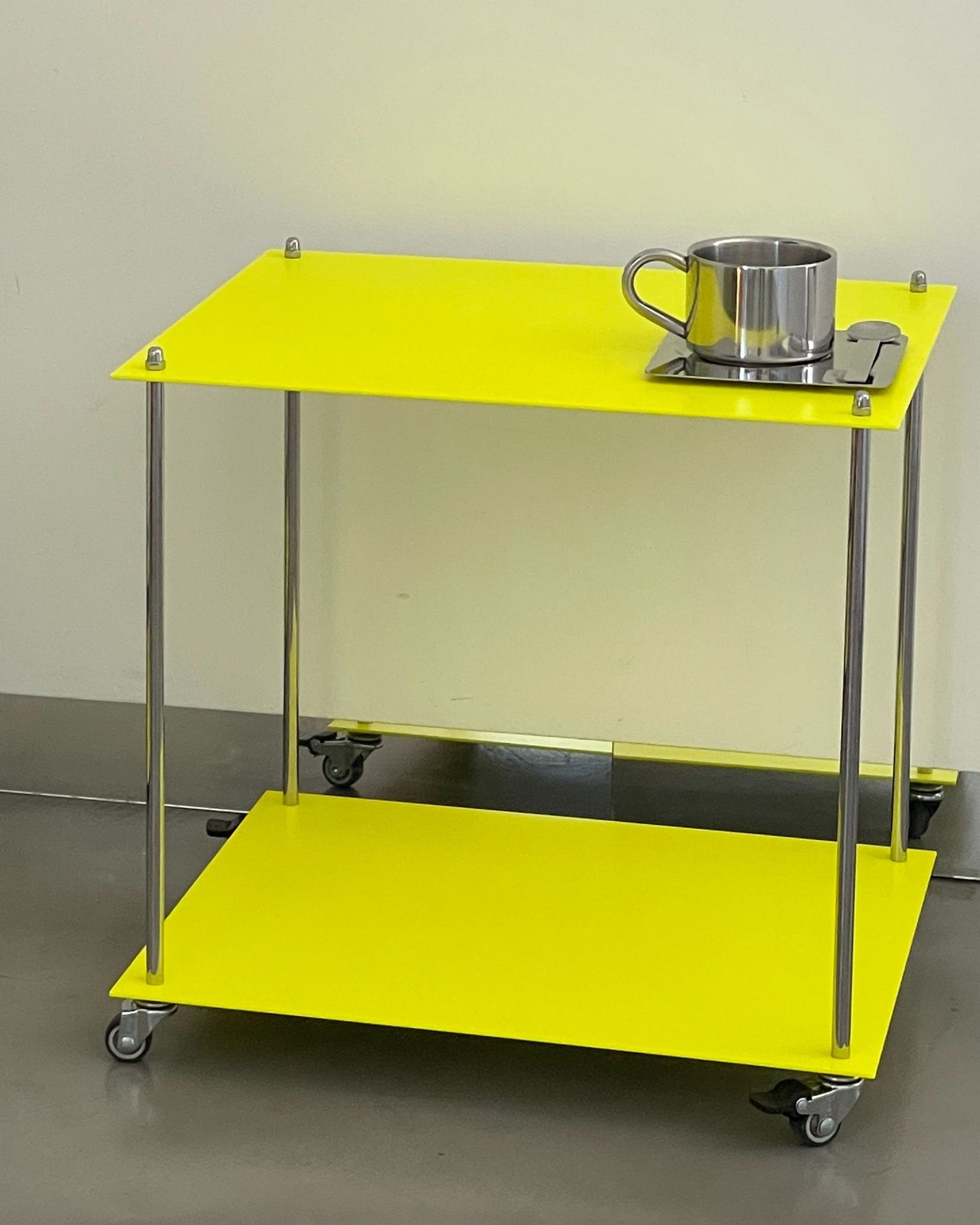 modulares Regal Modulum in Leuchtgelb mit Rollen und Edelstahlstruktur in Seitenansicht auf glattem Boden