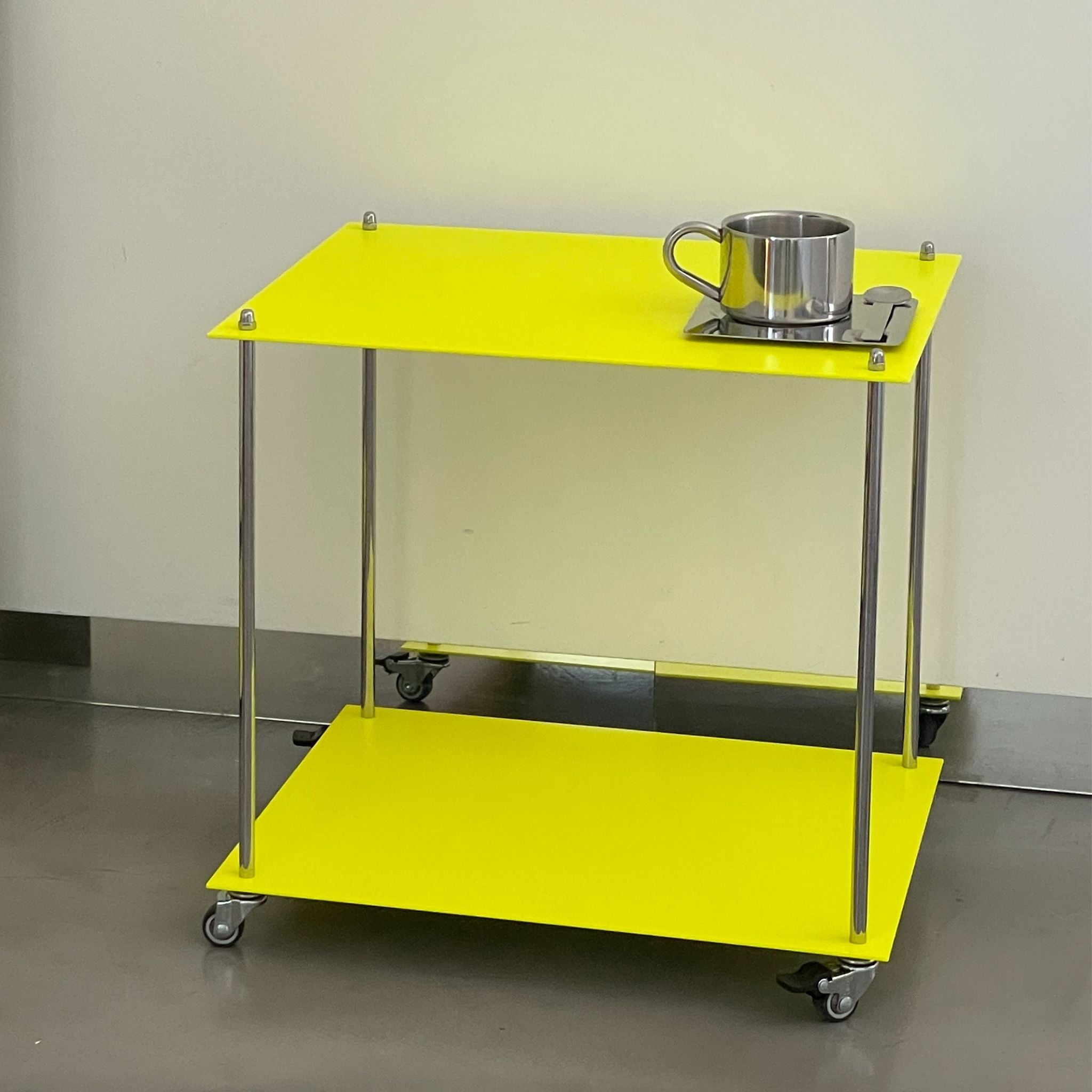 modulares Regal Modulum in Leuchtgelb mit Rollen und Edelstahlstruktur in Seitenansicht auf glattem Boden