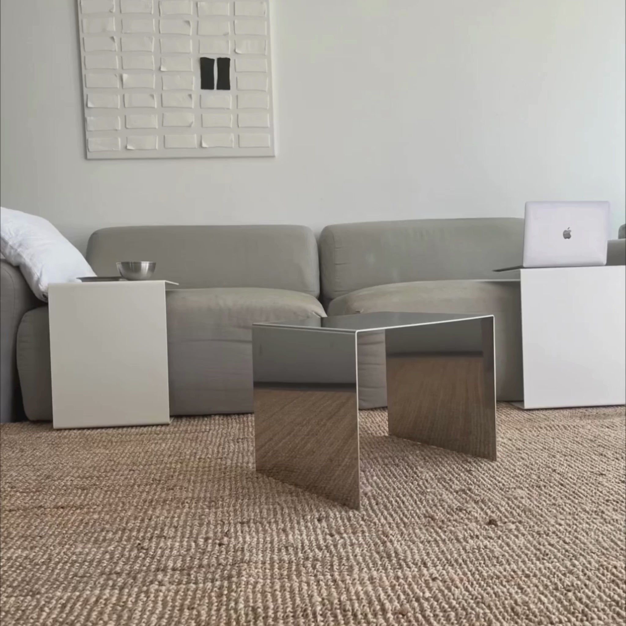 Couchtisch aus spiegelpoliertem Edelstahl im Wohnzimmer auf Ratan Teppich