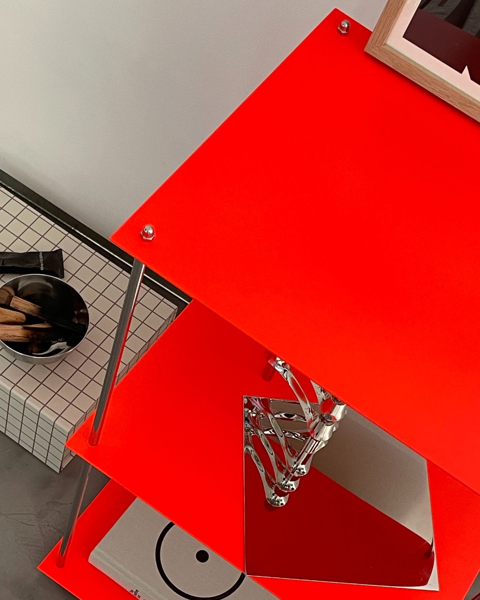 Detailansicht des leuchtroten Regals mit pulverbeschichteten Böden und polierten Streben von MO INTERIORS