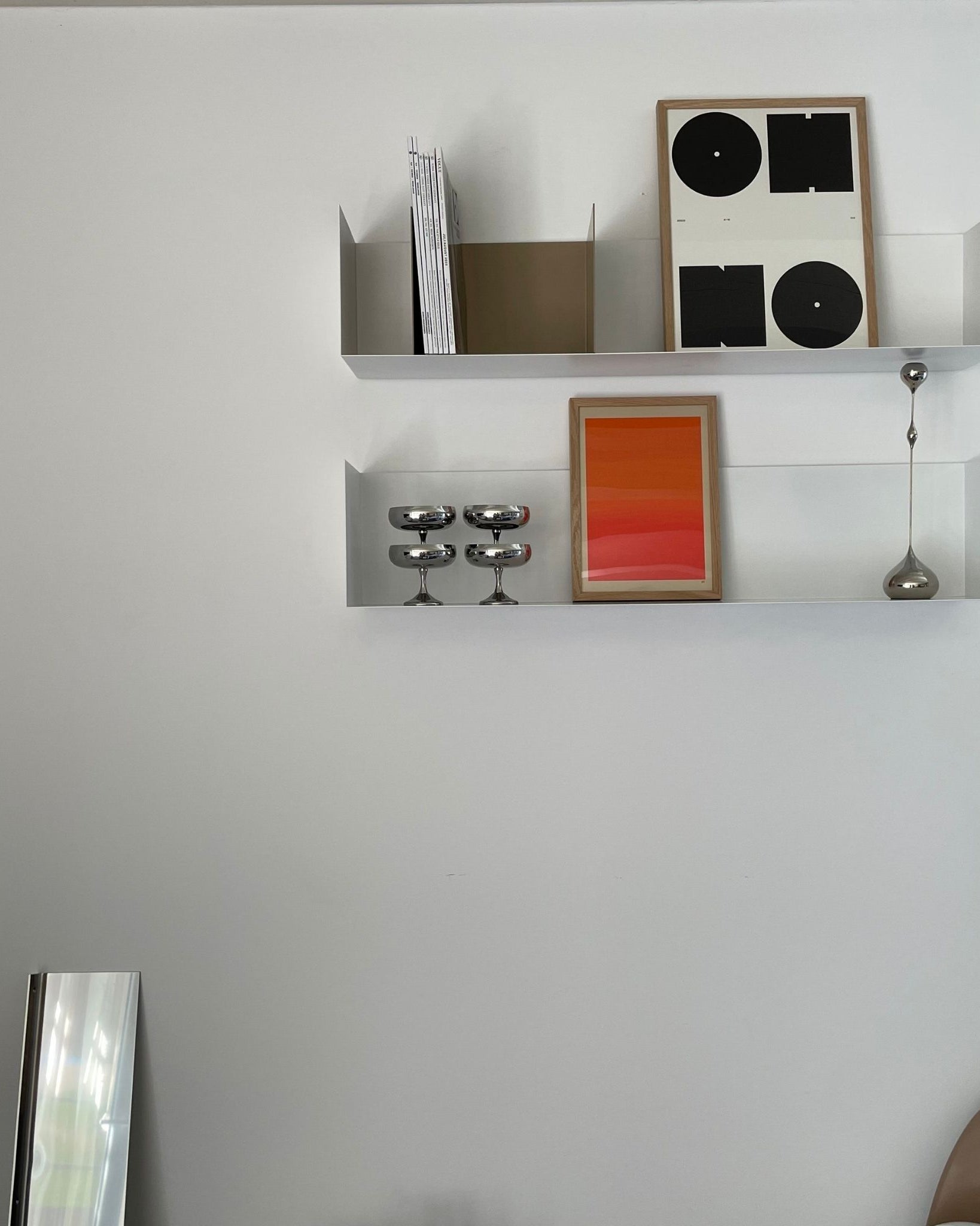 Modernes weißes Wandregal mit minimalistischer Dekoration, Kunstwerken und Edelstahl-Accessoires