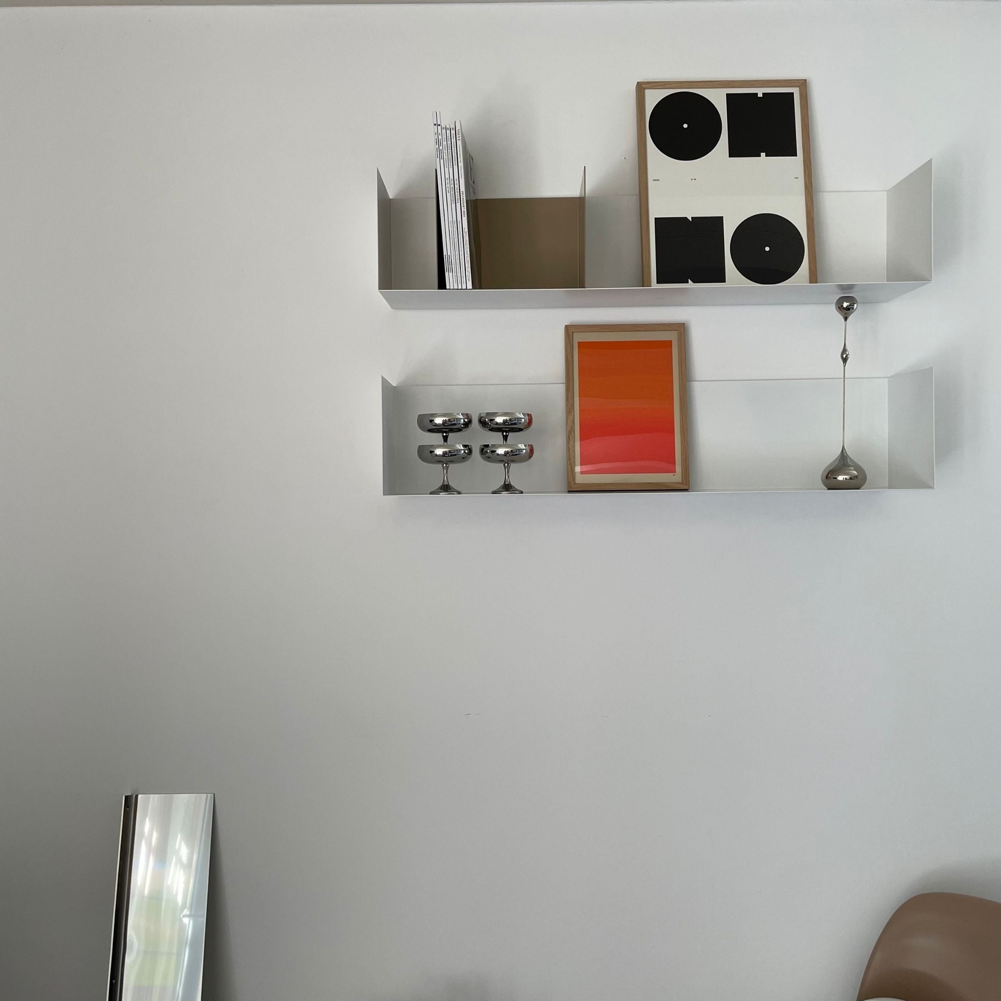 Modernes weißes Wandregal mit minimalistischer Dekoration, Kunstwerken und Edelstahl-Accessoires