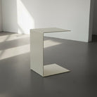 BIG C in cremeweiß auf grauen Betonboden vor weißer Wand und Lichtspiel