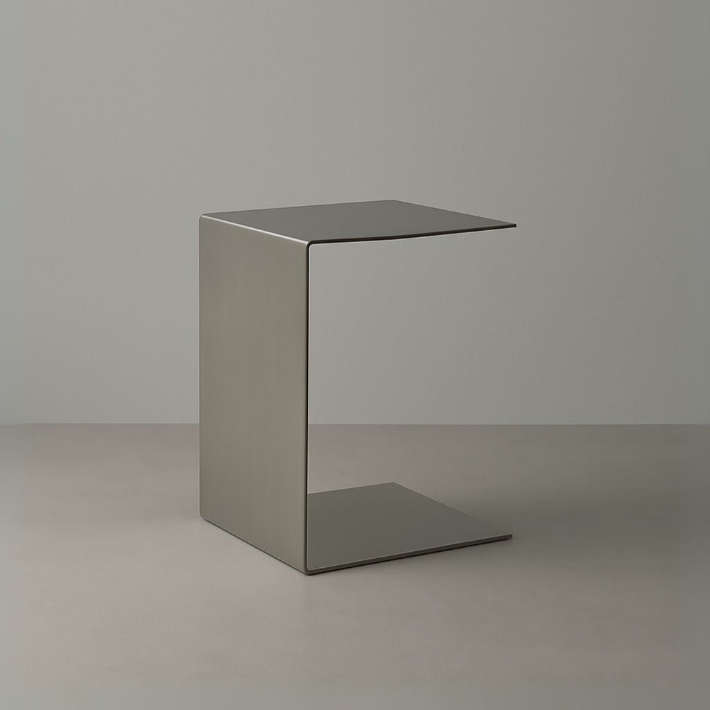 Beistelltisch Brushed C aus gebürstetem Edelstahl im minimalistischen C-Design auf hellem Boden vor grauer Wand