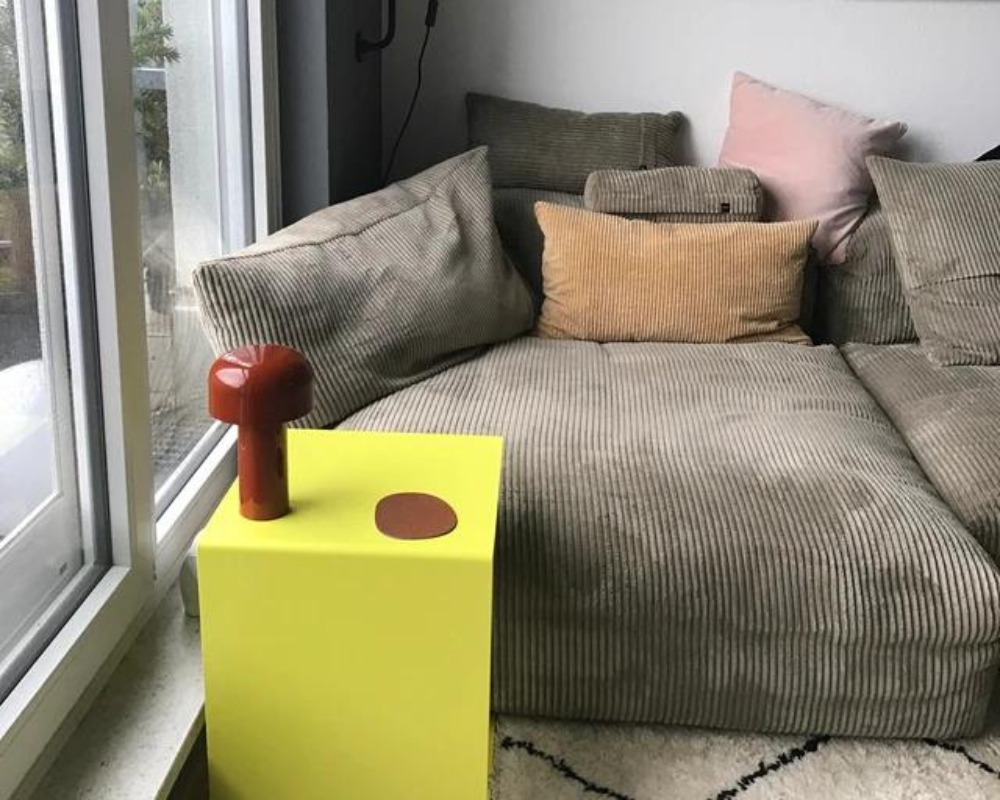 Kundenfoto - gelber Beistelltisch mit roter Lampe neben grauen Cordsofa