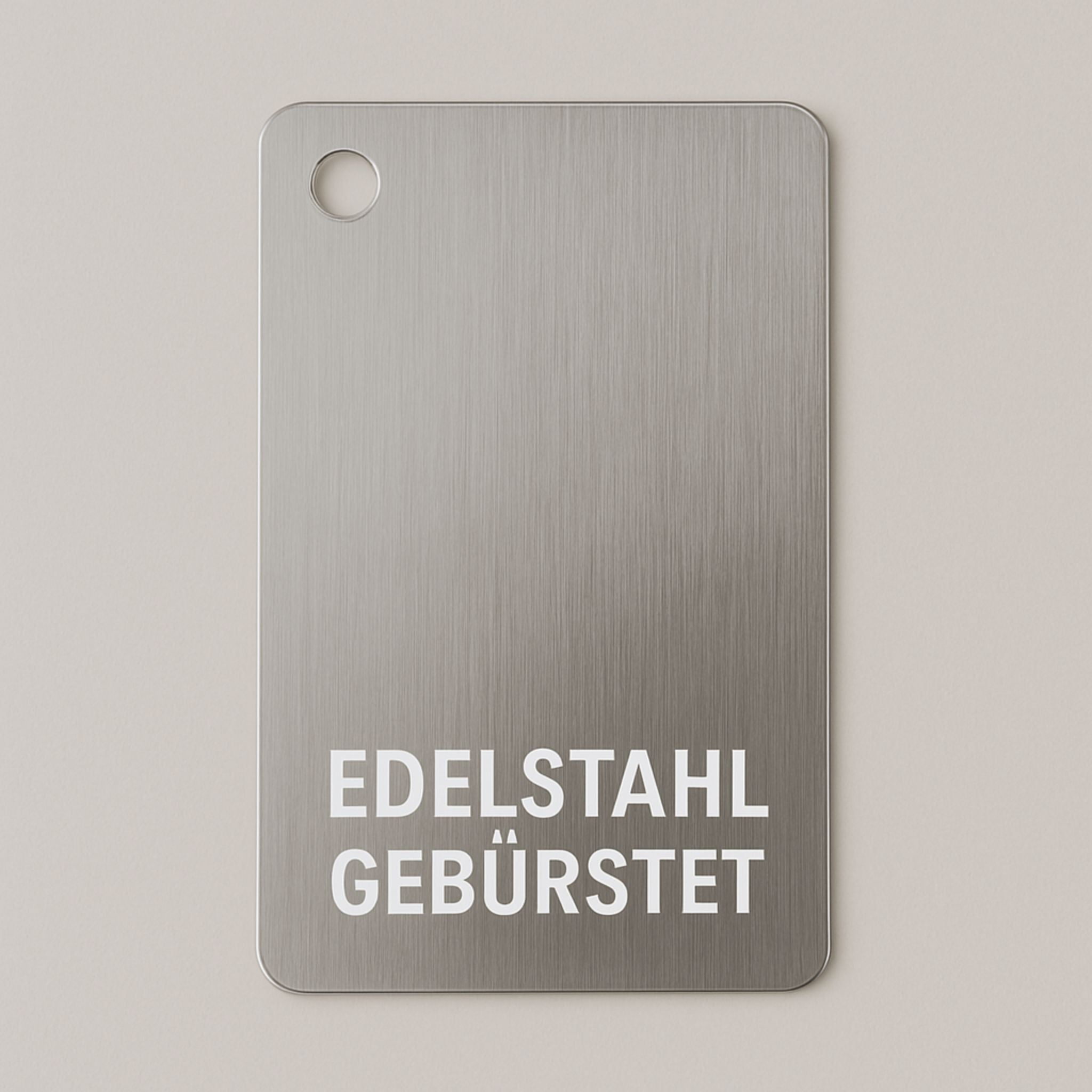 Materialmuster aus gebürstetem Edelstahl von MO INTERIORS mit runden Ecken und Bohrung oben links, für Möbel und Designobjekte