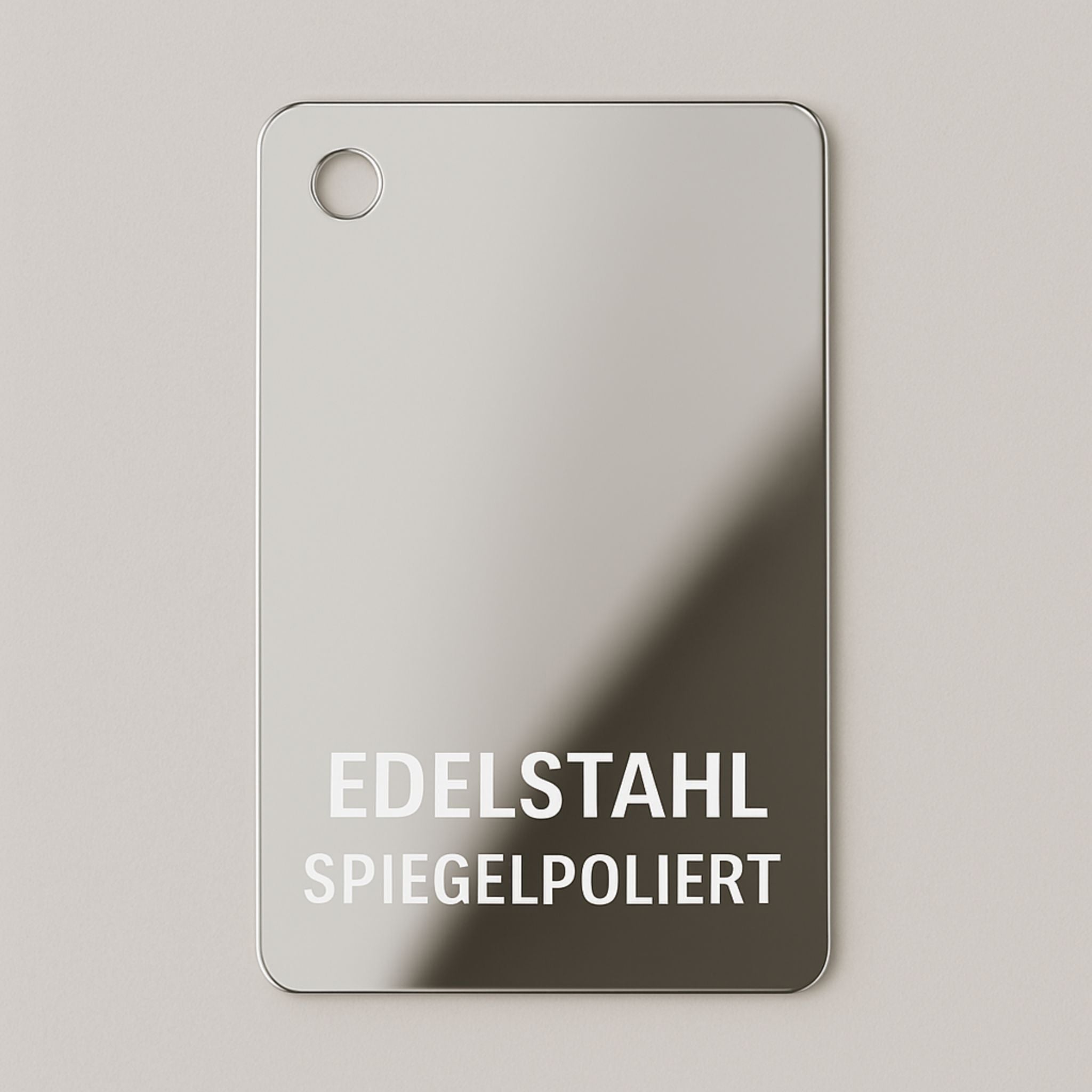 Materialmuster aus spiegelpoliertem Edelstahl von MO INTERIORS mit runden Ecken und Bohrung oben links, für Möbel und Designobjekte