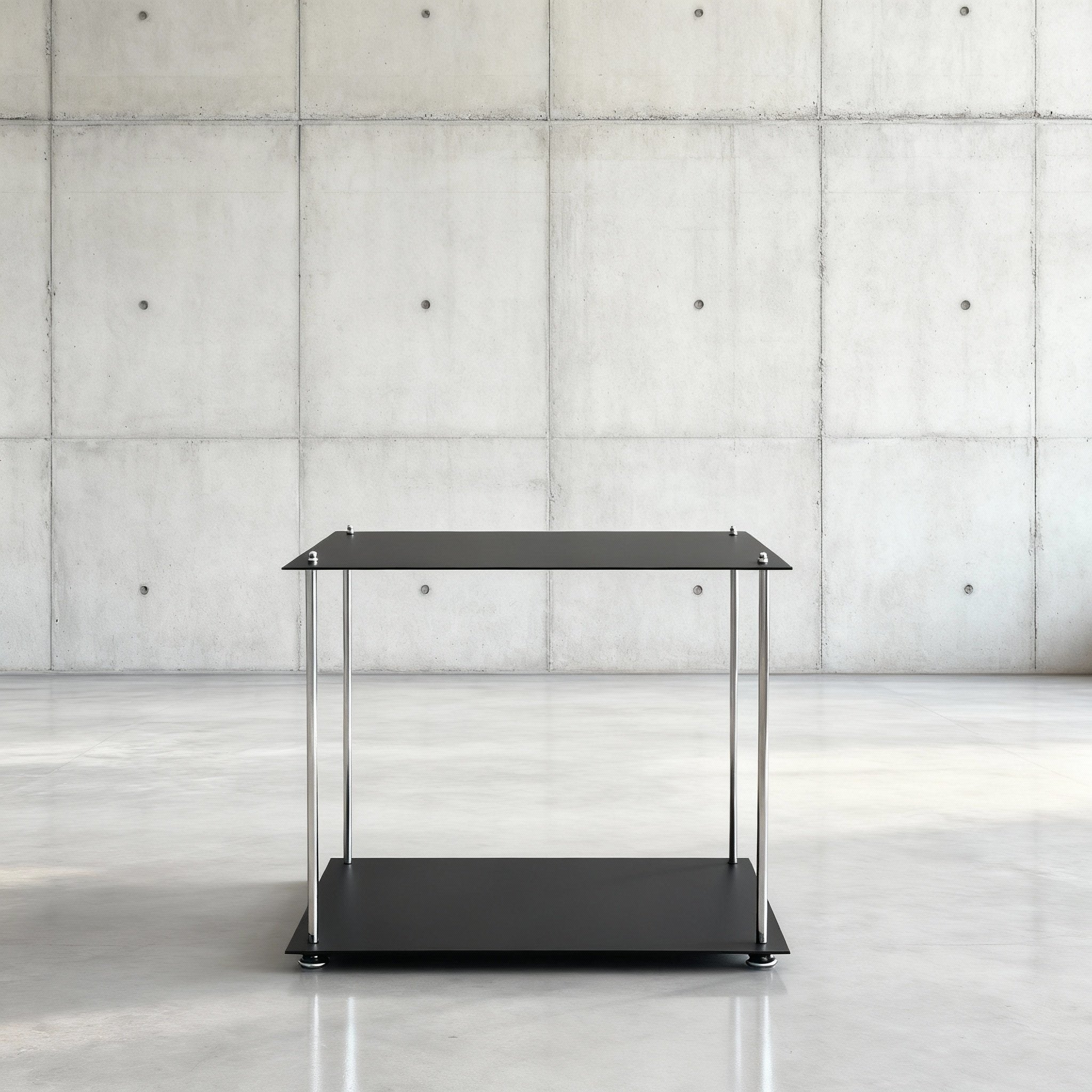 Modulum Basismodull schwarz ultramatt auf grauen Betonboden vor grauer Betonwand mit Löchern