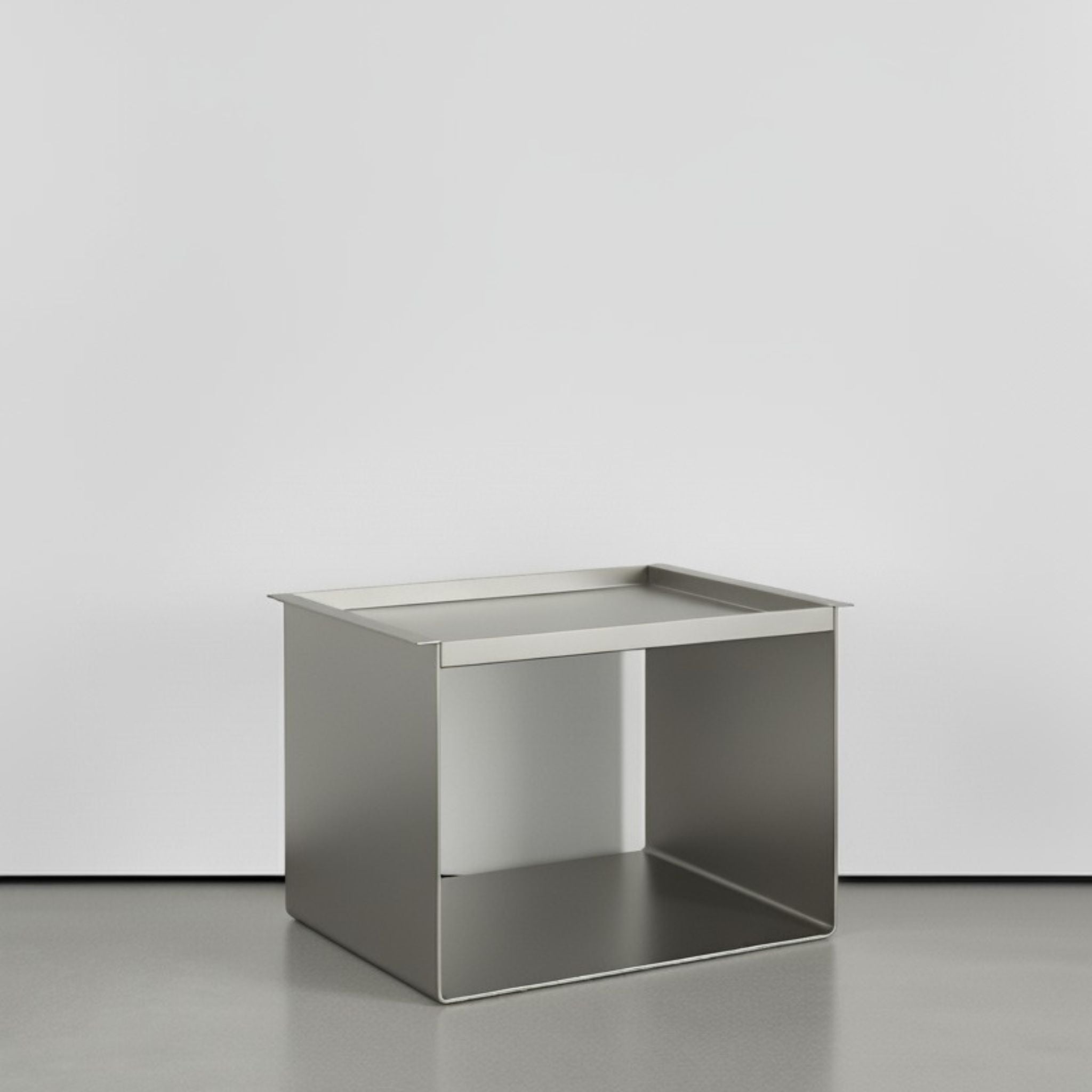 Tray Table Brushed C aus Edelstahl gebürstet auf grauen Betonboden vor weißer Wand und Lichtspiel