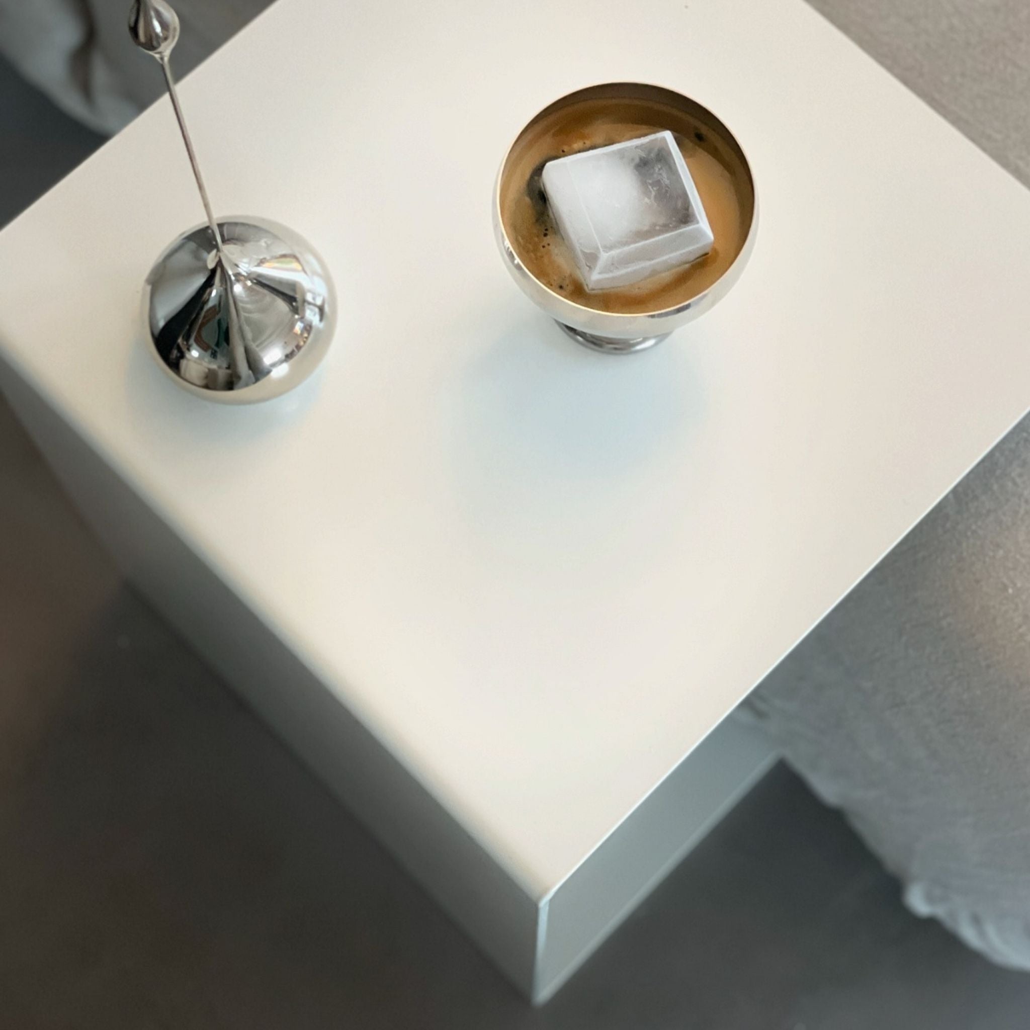 Weißer minimalistischer Beistelltisch mit Edelstahl-Dekoration und Kaffee