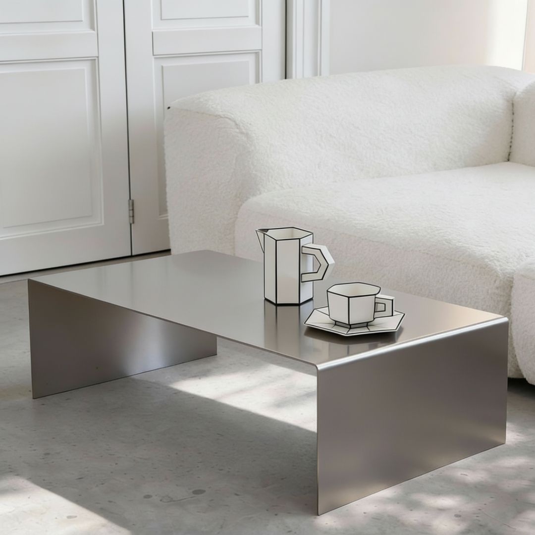 Brushed C Long Couchtisch aus gebürstetem Edelstahl vor Sofa im minimalistischen Wohnraum mit ruhiger Lichtstimmung
