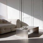 Brushed C Long Couchtisch aus gebürstetem Edelstahl im Wohnraum mit natürlichem Lichteinfall und klarer Linienführung