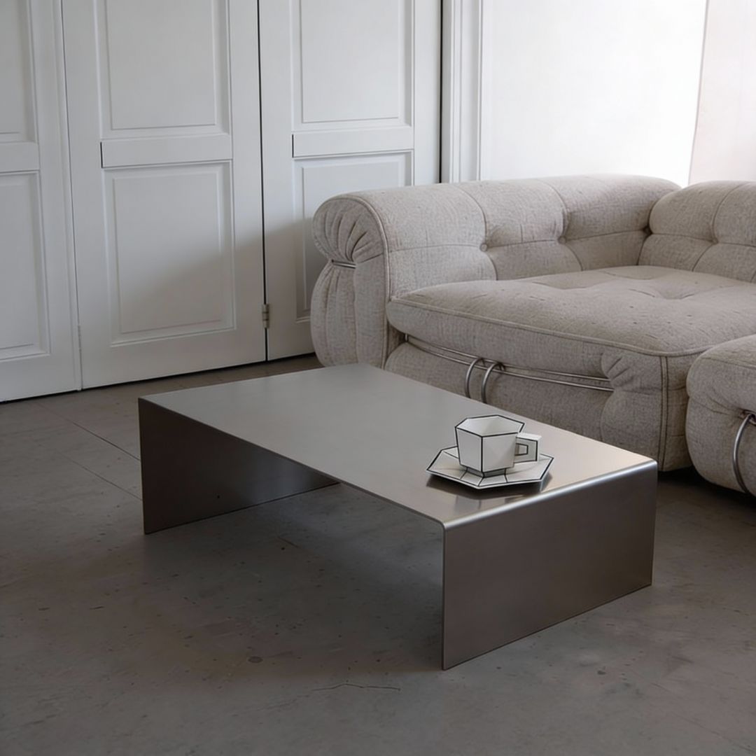 Brushed C Long Couchtisch aus gebürstetem Edelstahl im Wohnzimmer vor Sofa mit ruhiger, minimalistischer Raumwirkung