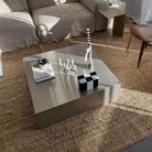 Moderner Couchtisch aus gebürstetem Edelstahl in stilvollem Wohnzimmer mit Design-Dekoration und natürlichem Lichteinfall