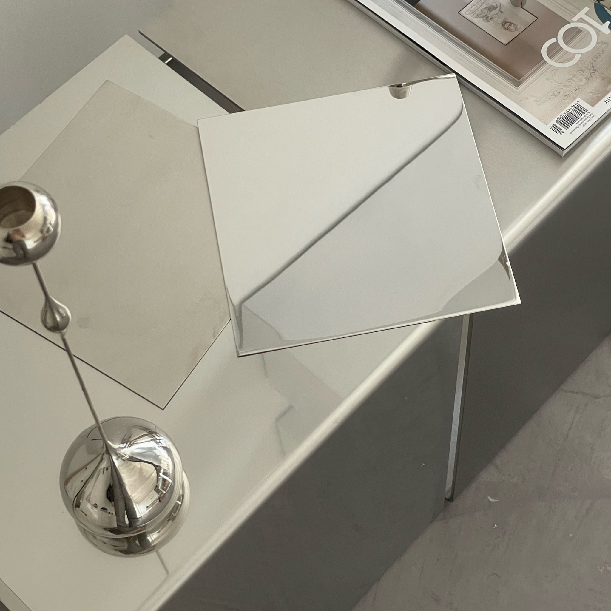 Couchtisch mit spiegelpolierter und gebürsteter Edelstahloberfläche, dekoriert mit Design-Accessoires