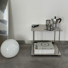 Modernes Design-Regal aus Edelstahl mit Espressokanne, Tasse und Designmagazinen