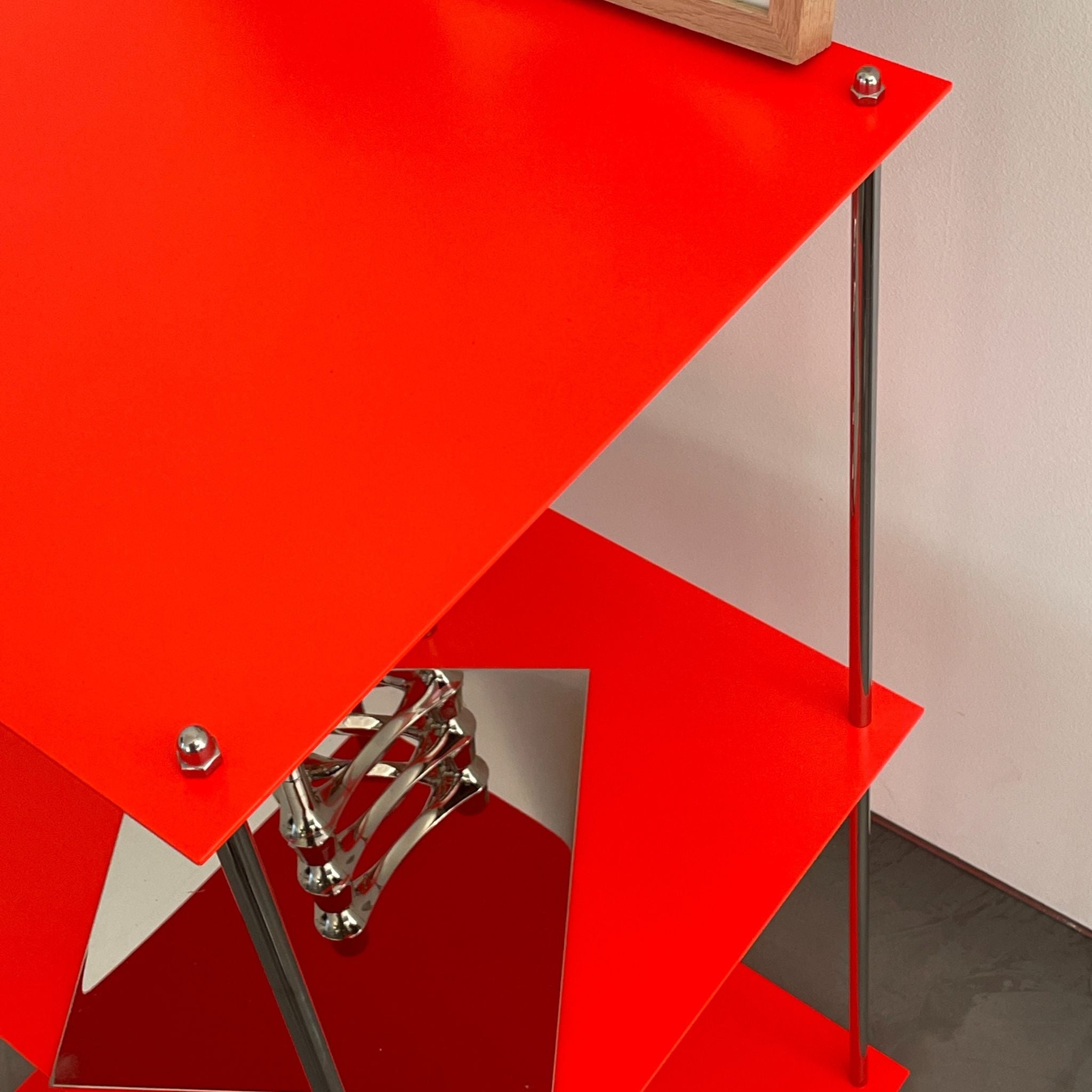 Detailansicht des leuchtroten Designregals mit pulverbeschichteten Böden von MO INTERIORS