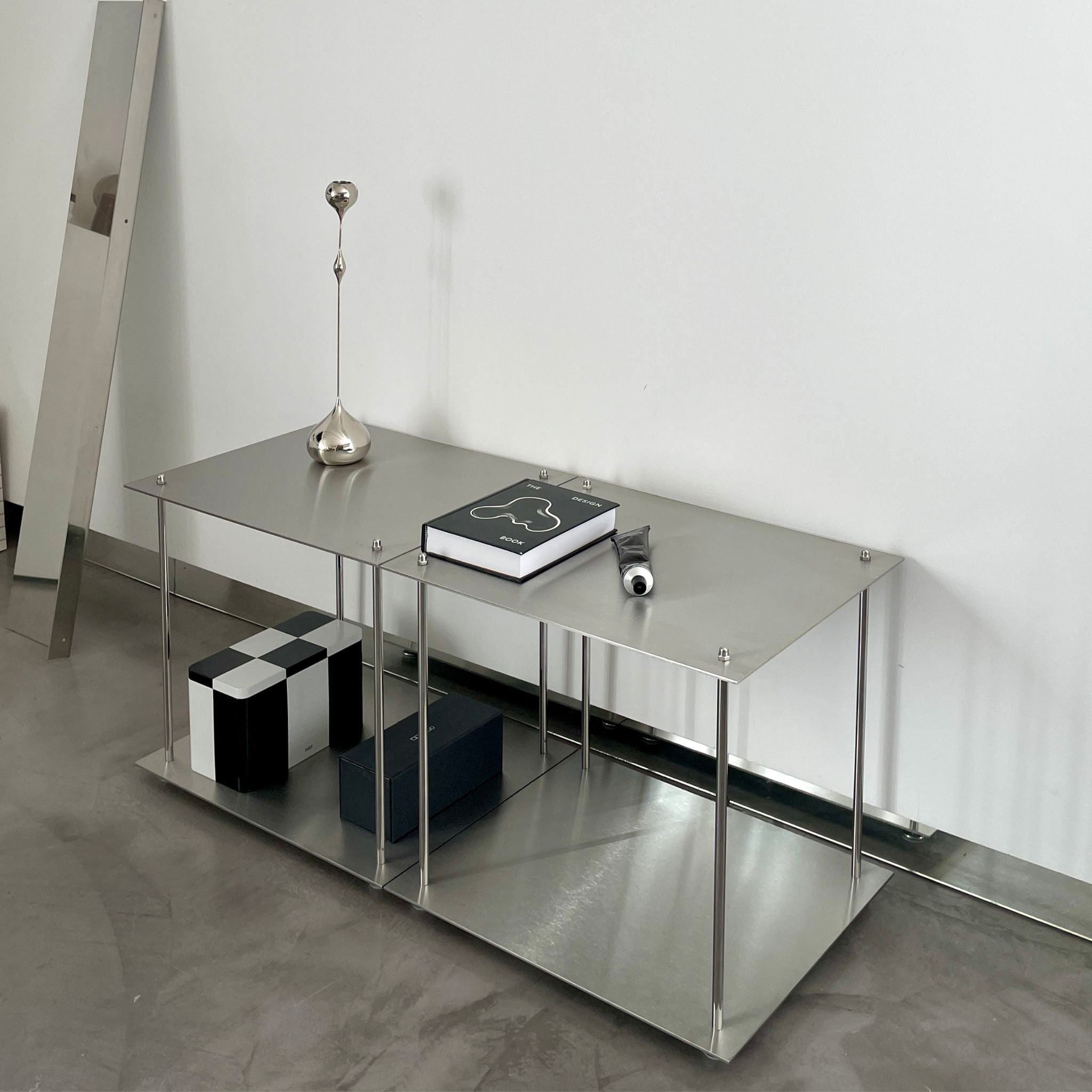 Modulares Lowboard aus Edelstahl mit Designobjekten und Aufbewahrungsboxen in minimalistischem Wohnraum