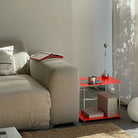 Modulares Regalsystem in leuchtrot als Beistelltisch neben Sofa mit Lampe, Tasse und dekorativen Boxen