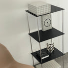 Schwarzes Stahlregal von MO INTERIORS mit Designobjekten und Kunstbüchern in modernem Wohnambiente