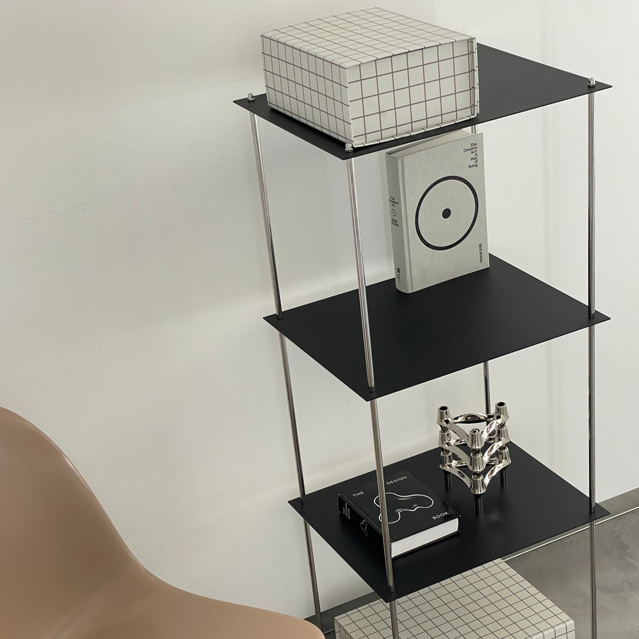 Schwarzes Stahlregal von MO INTERIORS mit Designobjekten und Kunstbüchern in modernem Wohnambiente