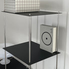 Detailansicht eines schwarzen Designregals von MO INTERIORS mit grafischer Box und Buch im minimalistischen Interieur