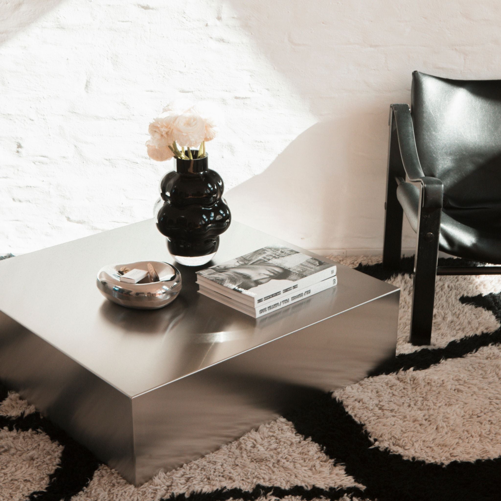 Moderner Couchtisch aus Edelstahl mit Dekoration in stilvollem Loft-Interieur