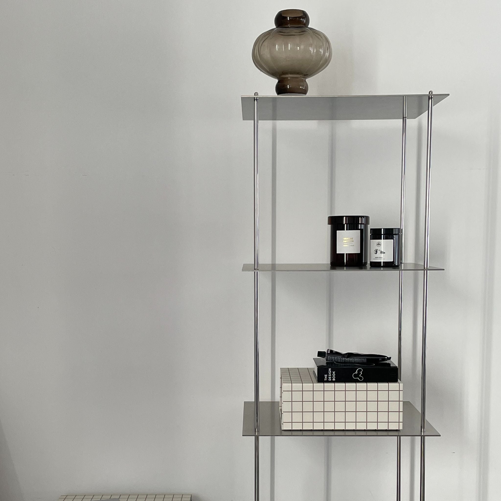 Hohes modulares Edelstahl-Regal mit minimalistischer Ästhetik und stilvoller Dekoration