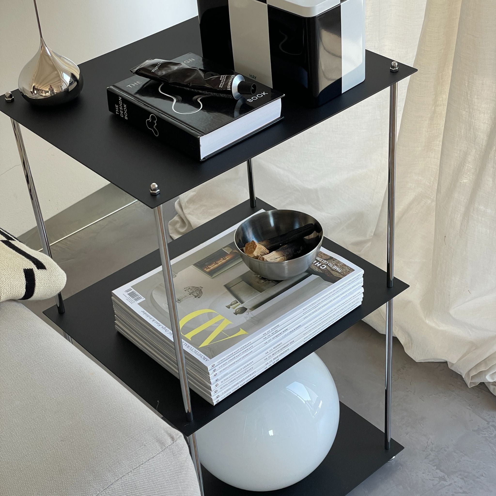 Modernes schwarzes Regal mit pulverbeschichteten Böden und Designobjekten im Wohnzimmer