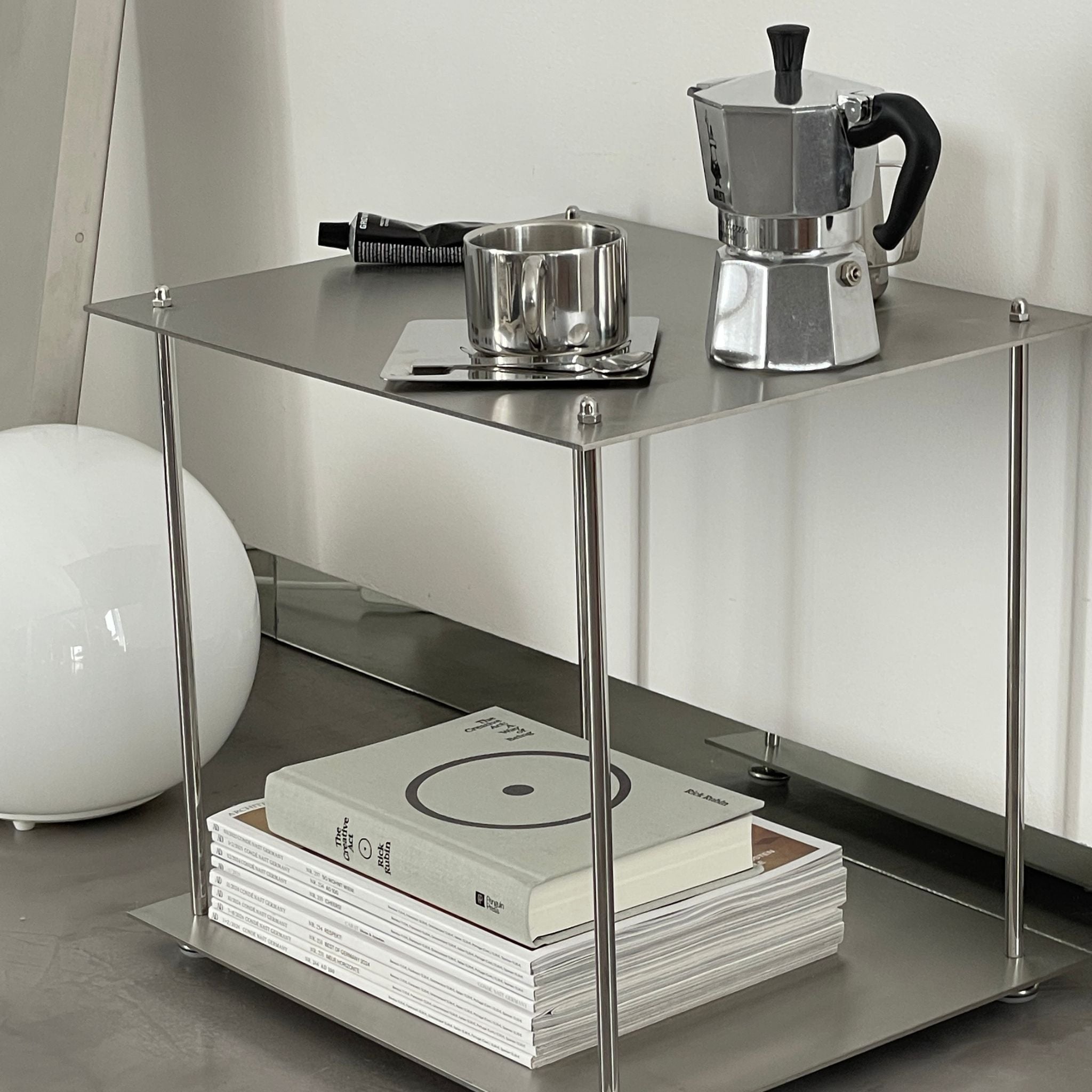 Modulares Regalsystem aus Edelstahl mit Kaffeemaschine, Tasse und Designmagazinen