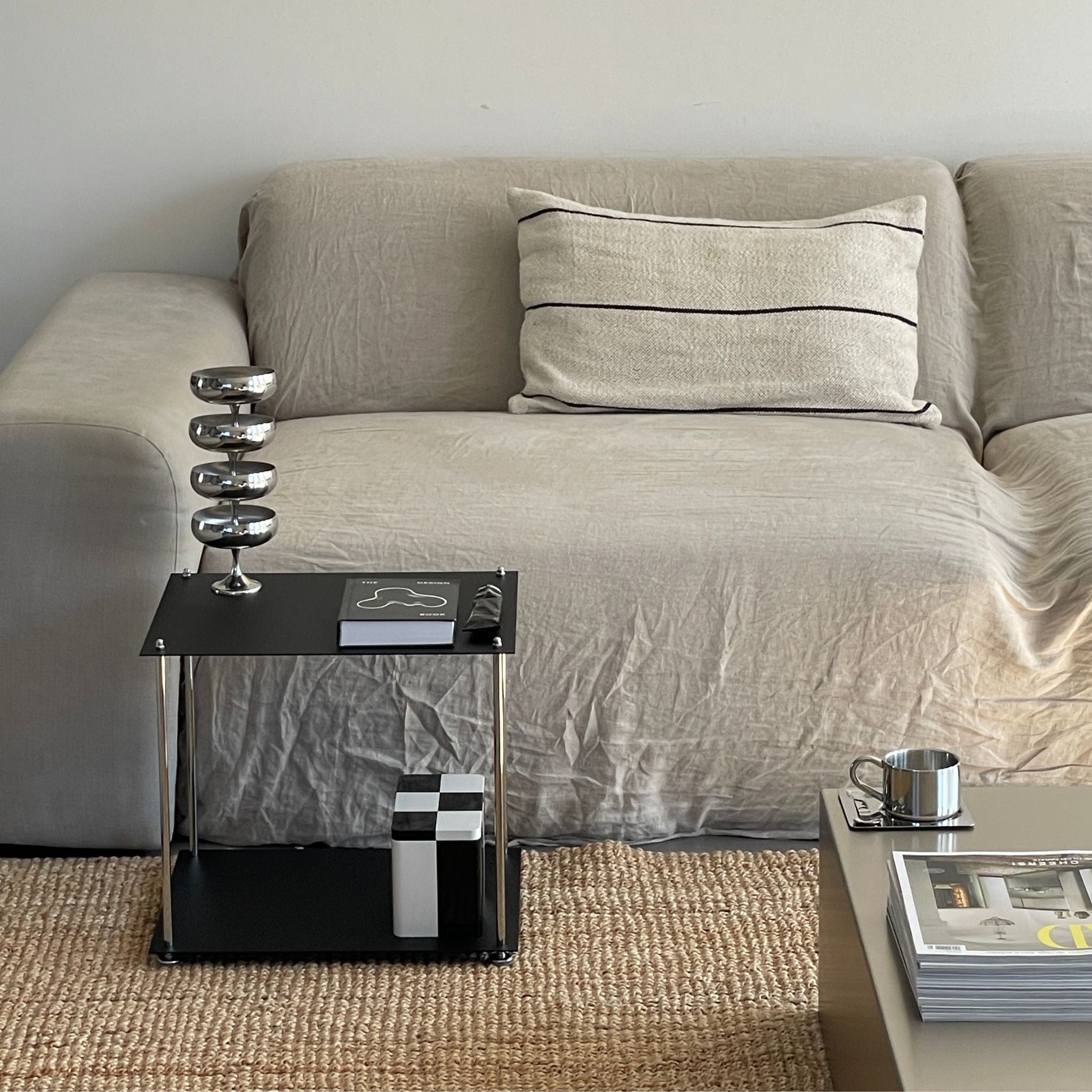 Schwarzes MODULUM Regal mit Pulverbeschichtung als stilvoller Beistelltisch neben beigem Sofa im Wohnzimmer