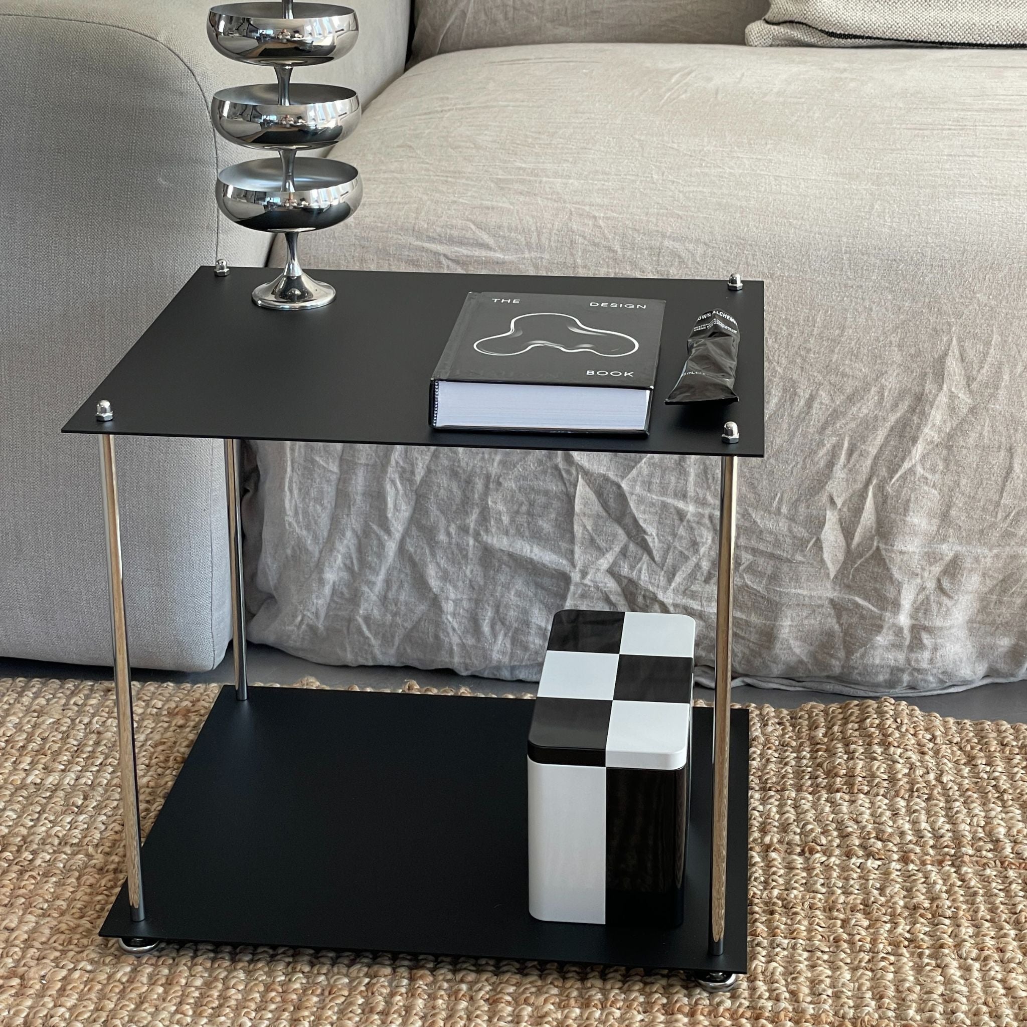 MODULUM Beistelltisch in Schwarz matt neben Sofa mit Designobjekten, minimalistisches Möbelstück für moderne Räume