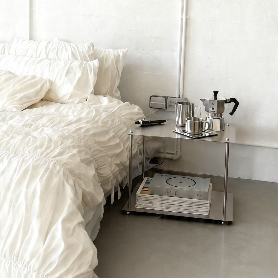 Modulares Regalsystem aus Edelstahl als Nachttisch im minimalistischen Schlafzimmer mit Kaffeeset und Stauraum