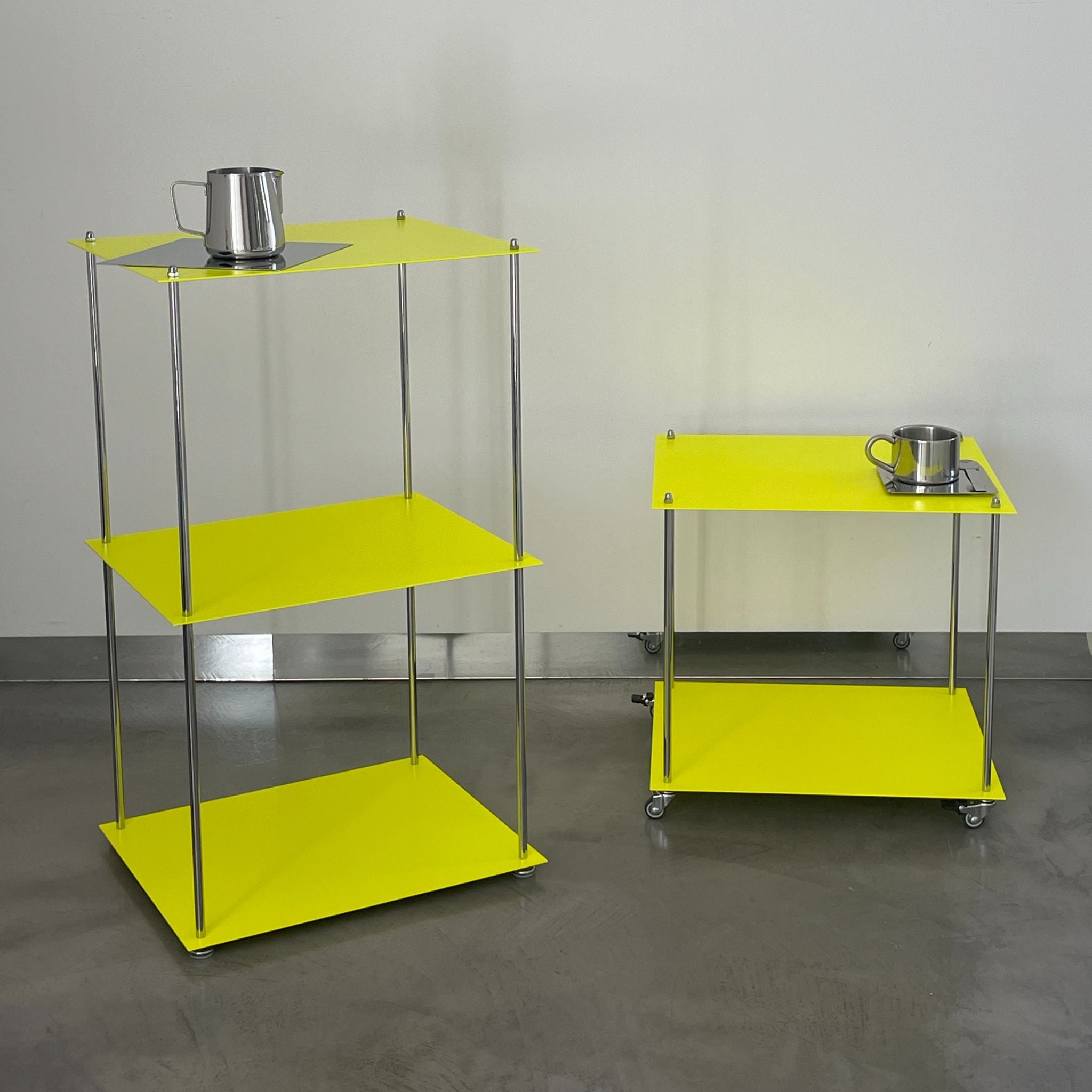 MODULUM Regal und Rollmodul in Leuchtgelb mit Edelstahlgestell auf grauem Boden vor weißer Wand