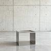 360 Grad Kamerafahrt Tray Table Brushed C in gebürstetem Edelstahl  auf grauen Betonboden vor grauer Betonwand mit Löchern