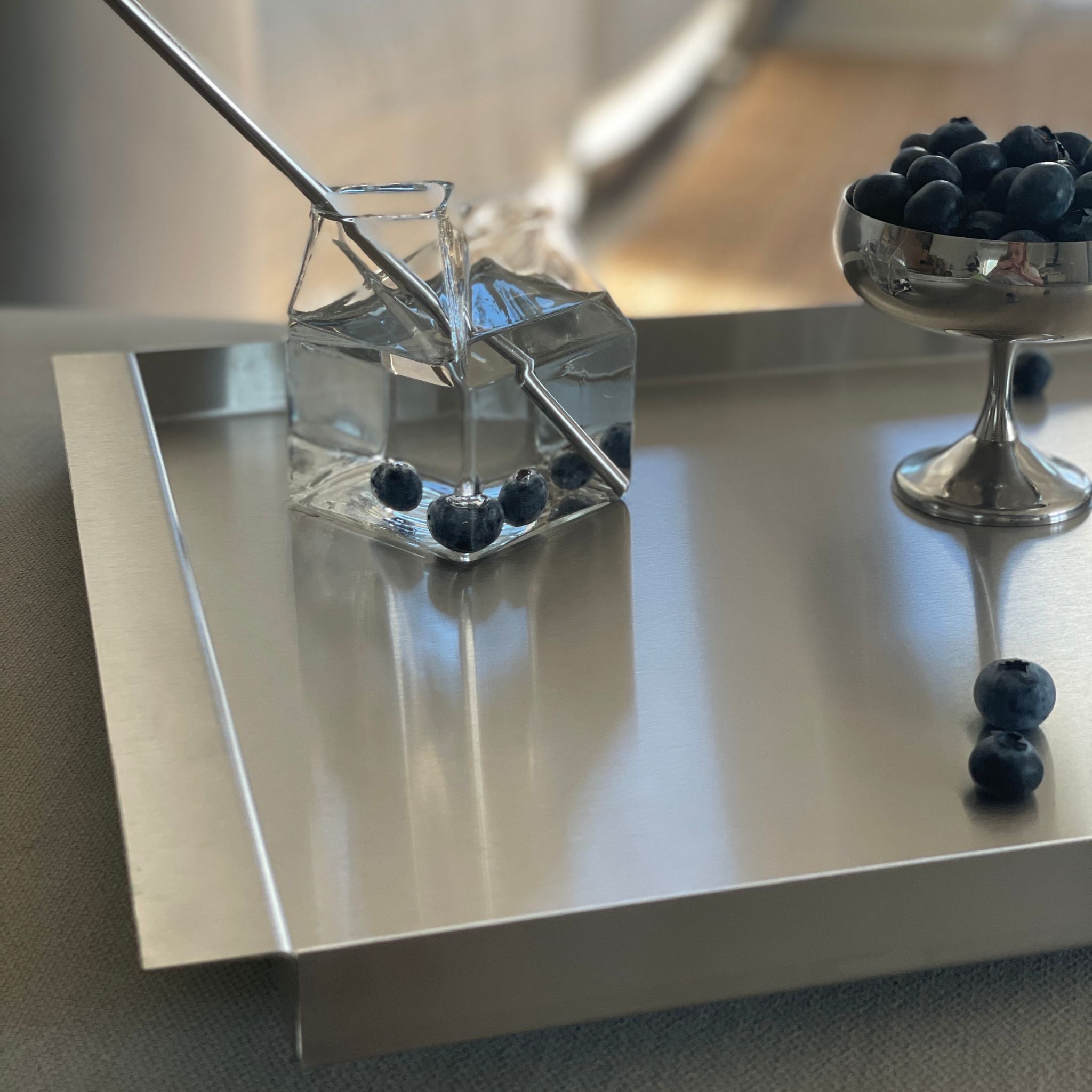 modernes edelstahl tablett mit wasser im milchkarton glas und blaubeeren